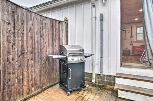 a grill sitting next to a fence next to a house at Cape Cod Vacation Rental Walk to Beach! in Dennis Port