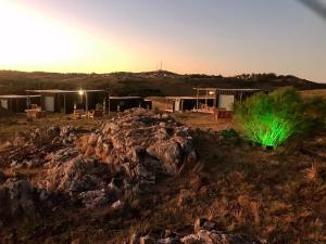 una casa con luz verde en un campo rocoso en Terrazas Suites Cabañas Boutique en Tandil