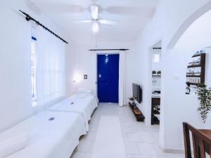 Habitación con paredes blancas y puerta azul. en Anticlea II en Ítaca