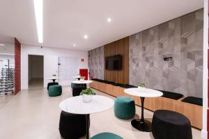 a waiting room with two tables and chairs at Studios Modernos Totalmente Mobiliados com Academia Próximo a Metrô Parque Ibirapuera e Hospitais in São Paulo