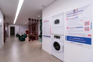 una lavanderia con lavatrice e asciugatrice appesa a un muro di Studios Modernos Totalmente Mobiliados com Academia Próximo a Metrô Parque Ibirapuera e Hospitais a San Paolo