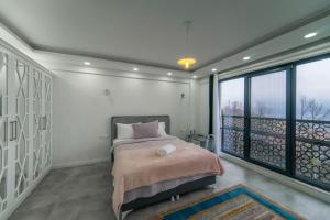 ein Schlafzimmer mit einem Bett und einem großen Fenster in der Unterkunft Sapanca villa in Sapanca