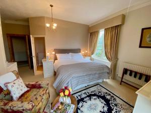 um quarto com uma cama e um sofá em Golborne Manor Bed and Breakfast em Chester