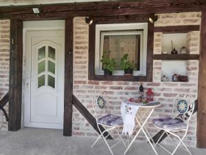 a room with two chairs and a table and a door at Apartment Ada bed & breakfast in Gračac