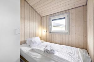 a small bedroom with a bed with towels on it at First Camp Lakolk Strand Camping in Lakolk