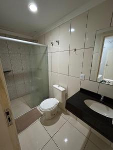 a bathroom with a toilet and a shower and a sink at Vitória Hotel - Guaíra PR in Guaíra