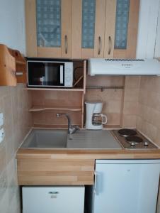 a small kitchen with a sink and a microwave at Le Surplage in Hyères