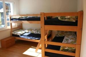 2 Etagenbetten in einem Zimmer mit Fenster in der Unterkunft Bädli im Munzenriet in Wildhaus