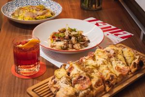 a table with a pizza and a bowl of food and a drink at SAHARA Las Vegas in Las Vegas