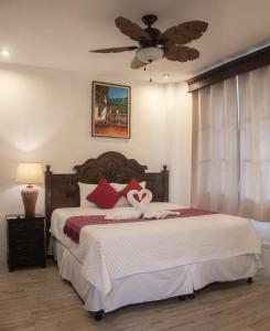 een slaapkamer met een bed en een plafondventilator bij Hotel Taa' Tiin in San Juan La Laguna