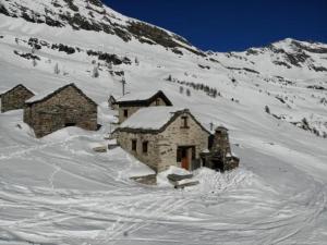 a building in the snow in front of a mountain at Rustico "Casi Hütte" in Bosco Gurin