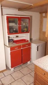 uma cozinha com armários vermelhos e um frigorífico branco em Ferienwohnung Südhang Rüschegg em Rüschegg