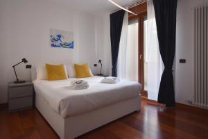 a bedroom with a white bed with yellow pillows at Padova Business Luxury Terrace in Padova