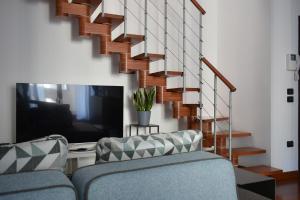 a living room with a couch and a staircase at Padova Business Luxury Terrace in Padova
