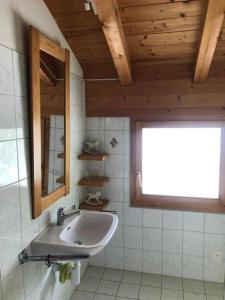 a bathroom with a sink and a mirror and a window at Casa SagognLaax in Sagogn