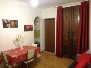 a dining room with a table and red curtains at Casa Colorata in Palermo