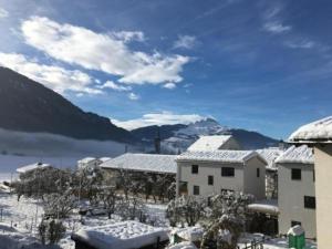 a town with snow covered buildings and a mountain at Casa SagognLaax in Sagogn