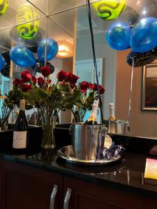 Balcony Suite Strip View في لاس فيغاس: كونتر به بالونات و مزهرية من الورود و زجاجات من الشمبانيا