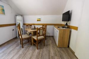 a small room with a table and chairs and a television at Aparthouse Bilic in Jajce