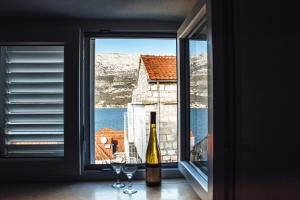 uma janela com uma garrafa de vinho e dois copos em Old Town Watch&C em Korčula
