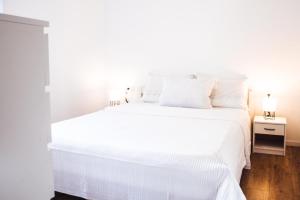 ein weißes Bett mit weißer Bettwäsche und Kissen in der Unterkunft Old Town Watch&C in Korčula