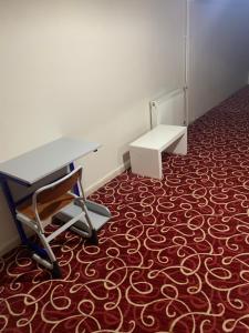 a room with a desk and a bench on a carpet at Amkara apart hostel 5 in Altındağ