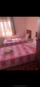 2 Betten in einem Schlafzimmer mit einer roten und weißen Decke in der Unterkunft Amkara apart hostel 5 in Altındağ