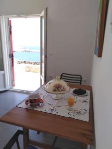 a table with a plate of food and drinks on it at Kythnos - Loutra- House in Loutrá