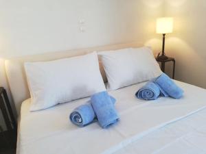 a white bed with blue towels on top of it at Kythnos - Loutra- House in Loutra