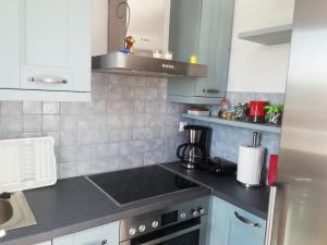 a kitchen with white cabinets and a black counter top at Kythnos - Loutra- House in Loutra +12 photos