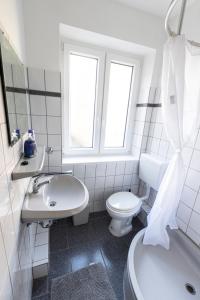 uma casa de banho branca com um WC e um lavatório em Bremerhavener Suite 5 em Bremerhaven