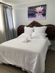 een wit bed met witte lakens en kussens bij UNIT 26 @ 77 on Independence in Windhoek