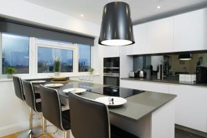 a kitchen with a dining table with chairs and a large window at Panther House by Oval in London