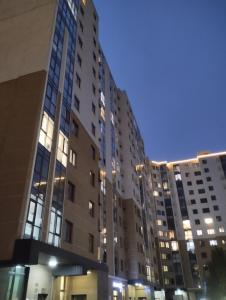 un grupo de edificios altos en una ciudad por la noche en Аккуратная 1-комнатная квартира в ЖК Nomad, en Almaty