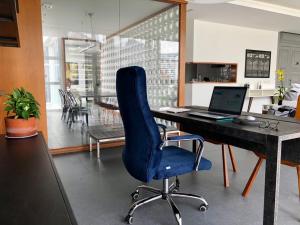 リオデジャネイロにあるIpanema com Todo Confortoのオフィス(青い椅子、ノートパソコン付きデスク付)