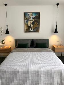 リオデジャネイロにあるIpanema com Todo Confortoの白いベッド1台付きのベッドルーム1室(壁に絵画付)