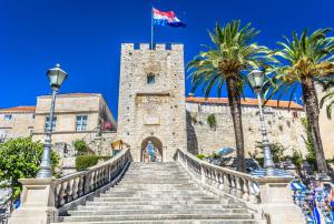 uma escada que leva a um castelo com uma bandeira sobre ele em Old Town Watch&C em Korčula