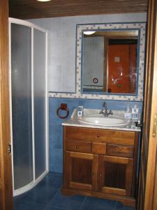 y baño con lavabo, espejo y ducha. en CASA RURAL SIMÓN, en Soto