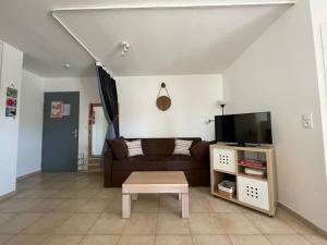 a living room with a couch and a coffee table at Appartement tout confort 2-4 pers 500 m de la plage avec piscine et wifi in Santa-Maria-Poggio