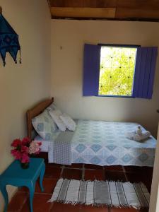a bedroom with two beds and a window at Chalé Flor do Ser in Canoa Quebrada