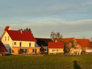 un grupo de casas con techos rojos y un campo en Ferienwohnung Weitblick, en Ravensburg