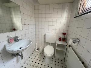 a bathroom with a toilet and a sink at Haus mit 4 Schlafmöglichkeiten in Hamburg