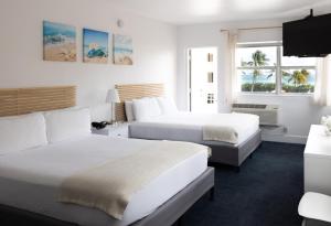 a hotel room with two beds and two windows at Lorraine Hotel in Miami Beach