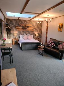 The Hideaway with hot tub في Chathill: غرفة معيشة مع سرير وأريكة