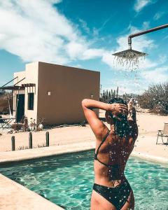 una mujer en bikini parada en una piscina en Desert Wind, en La Ventana