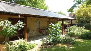 Casa con porche con mesa y sillas en Los Lirios en Sierra de los Padres