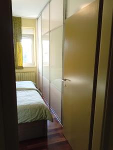 ein Schlafzimmer mit einem Bett und einer Schiebetür in der Unterkunft Apartment Laura in Pula