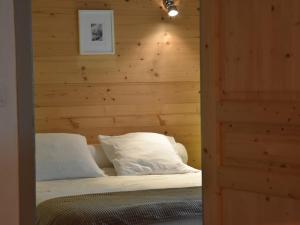 普拉洛尼昂拉瓦努瓦斯Appartement en centre-ville, proche des pistes, 4 personnes - FR-1-464-191的卧室里有一张床，墙是木的