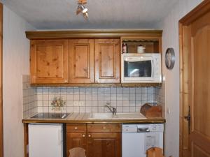 La cuisine est équipée de placards en bois, d'un évier et d'un four micro-ondes. dans l'établissement Appartement Pralognan-la-Vanoise, 4 pièces, 6 personnes - FR-1-464-181, à Pralognan-la-Vanoise