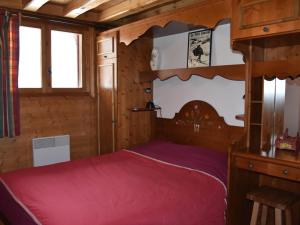 Cette chambre en bois comprend un lit rouge. dans l'établissement Appartement Pralognan-la-Vanoise, 4 pièces, 6 personnes - FR-1-464-181, à Pralognan-la-Vanoise